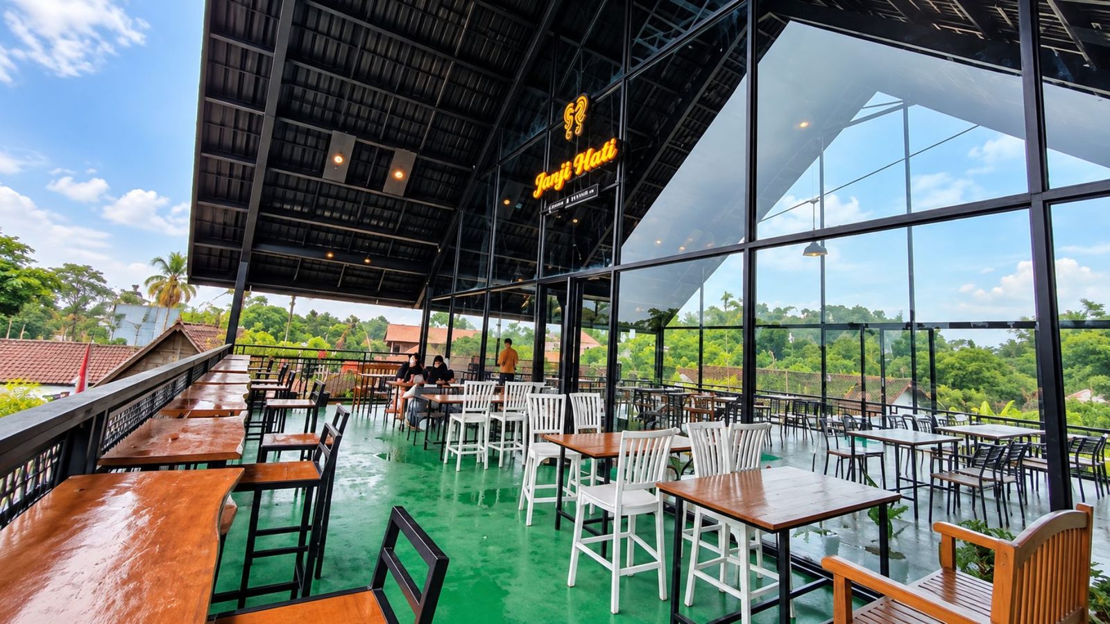 Terrace lantai atas Janji Hati Cafe Magelang dengan meja kayu dan view hijau